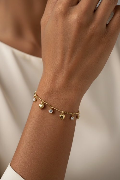 Trove Colombo Anastasia gold beaded bracelet with dangling heart charms and sparkling round crystals on a wrist