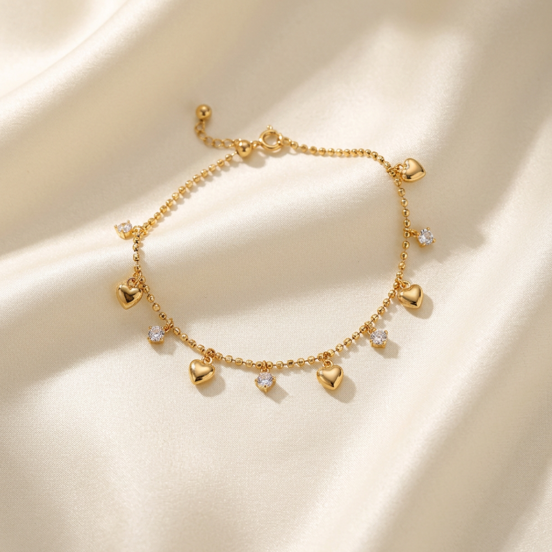 Trove Colombo Anastasia gold-tone beaded chain bracelet featuring dangling heart charms and sparkling crystal accents.