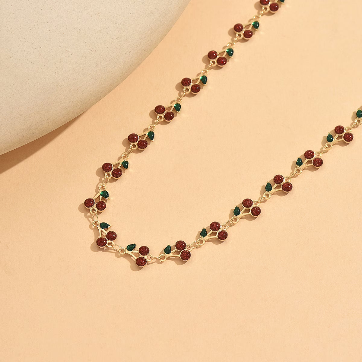 Trove Colombo Cheryl bohemian vintage copper chain necklace featuring a charming red and green cherry-inspired design.