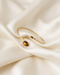 Trove Colombo Tiger Eye gold-tone alloy cuff bracelet featuring two teardrop-shaped tiger eye stone