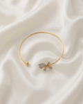 Trove Colombo Wisteria gold-tone iron choker necklace featuring a delicate grey floral charm